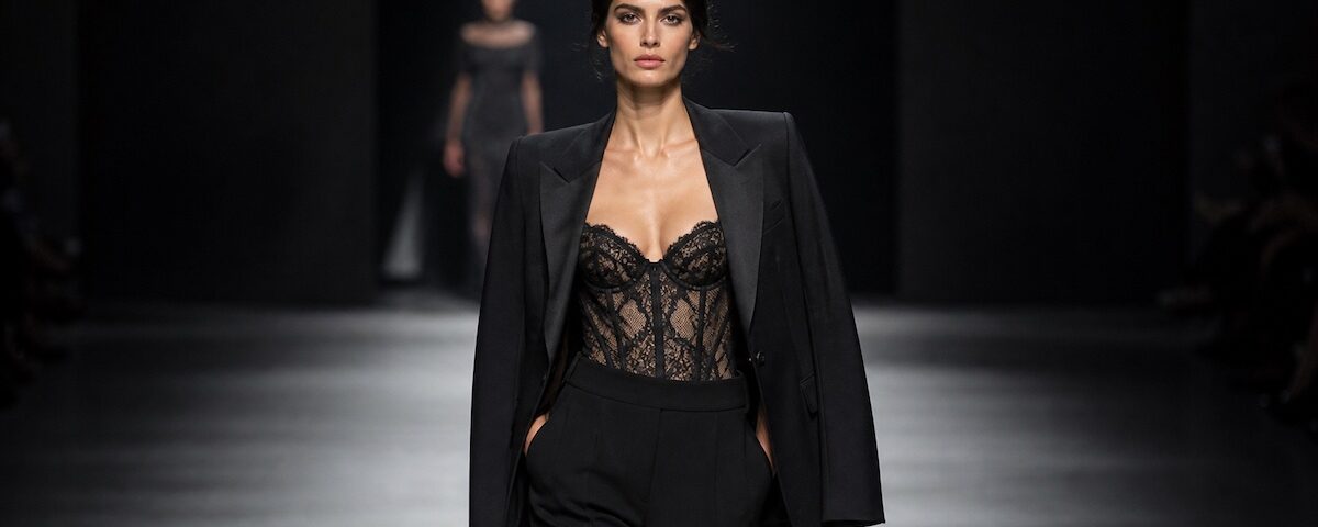 Outfit con blazer sartoriale e lingerie in pizzo su passerella di moda