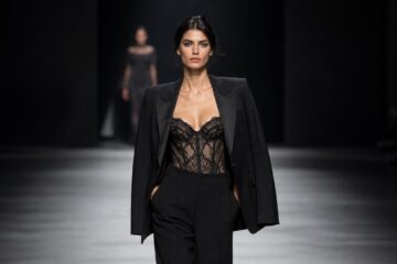 Outfit con blazer sartoriale e lingerie in pizzo su passerella di moda