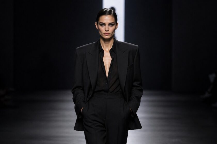 Modella con completo sartoriale nero su passerella fashion week