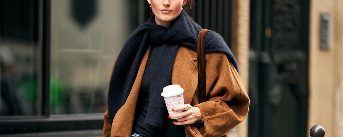 Donna in outfit elegante casual seduta in un caffè parigino