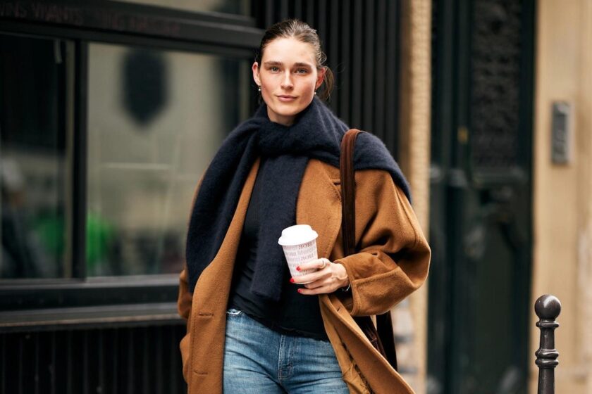 Donna in outfit elegante casual seduta in un caffè parigino